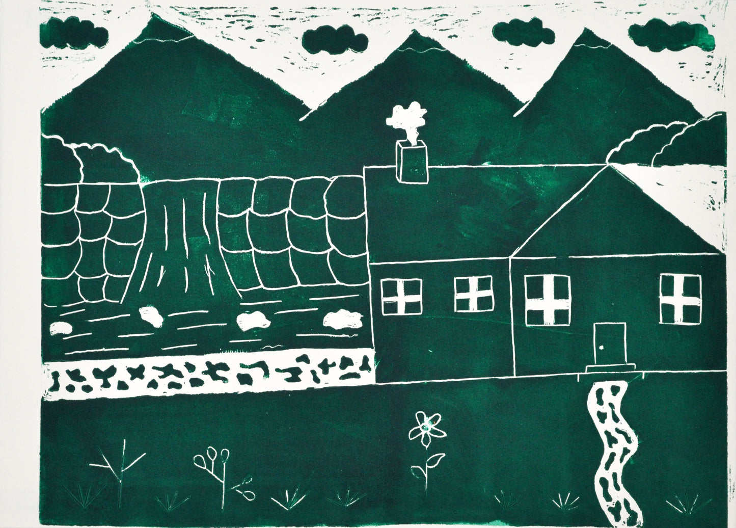 a linoleum cut print on white paper. The image is printed in dark green ink and depicts a house positioned on the far right, with a puff of smoke coming out of its chimney. To the left of the house are trees, a stone path, and flowers. Behind the house are 3 pointy mountains and four puffy green clouds floating across a white sky.