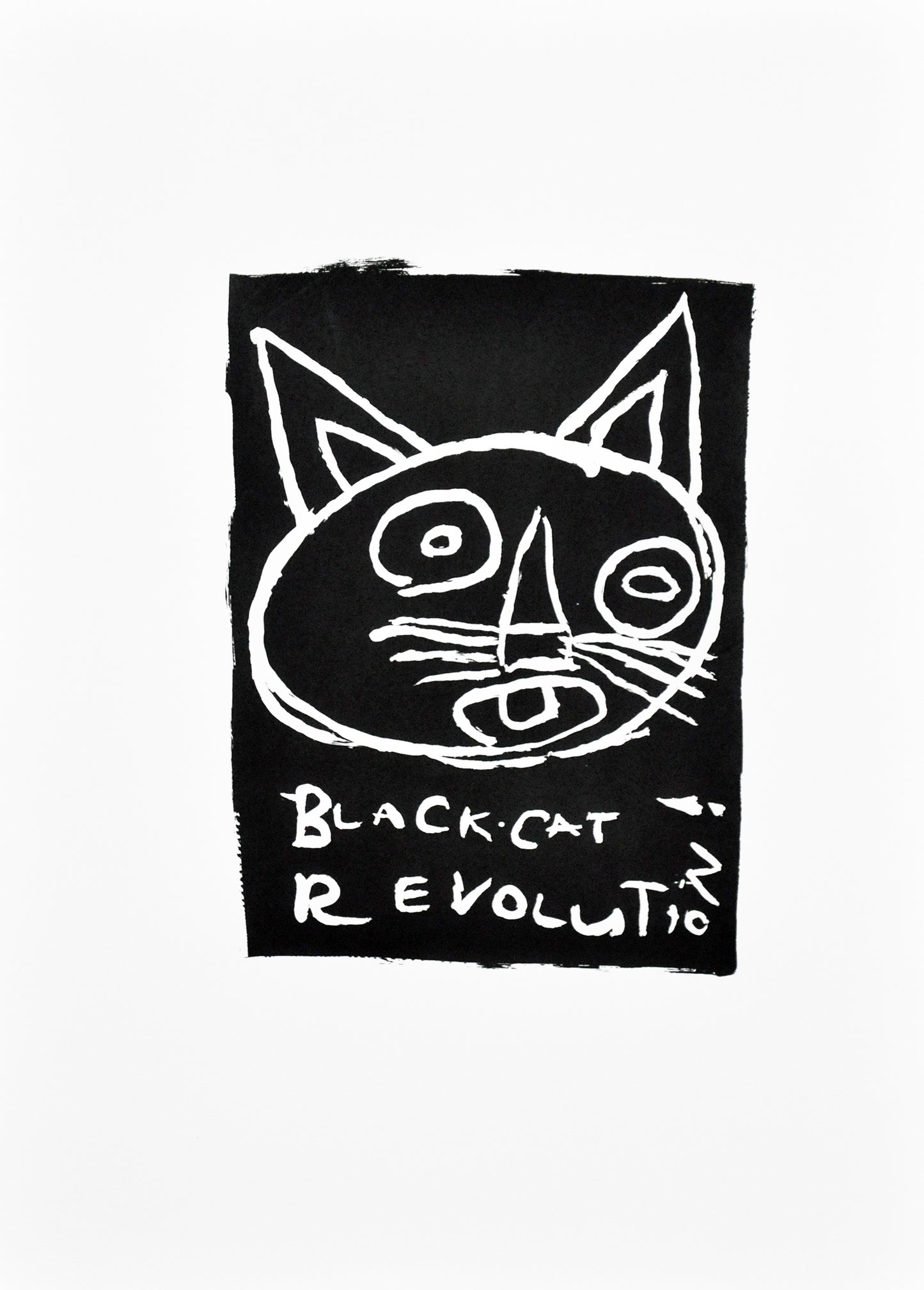 a print in black and white - a cat's head with large ears and wide open eyes. Text below reads "black cat revolution".