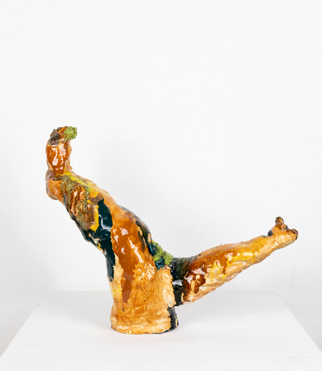 This is an abstract ceramic sculpture that resembles two upward-extending legs. The glossy surface features layered glazes, underglazes and Egyptian paste in earthy tones—rust orange, deep green, black, cream, and hints of yellow—with textured patches and drips.
