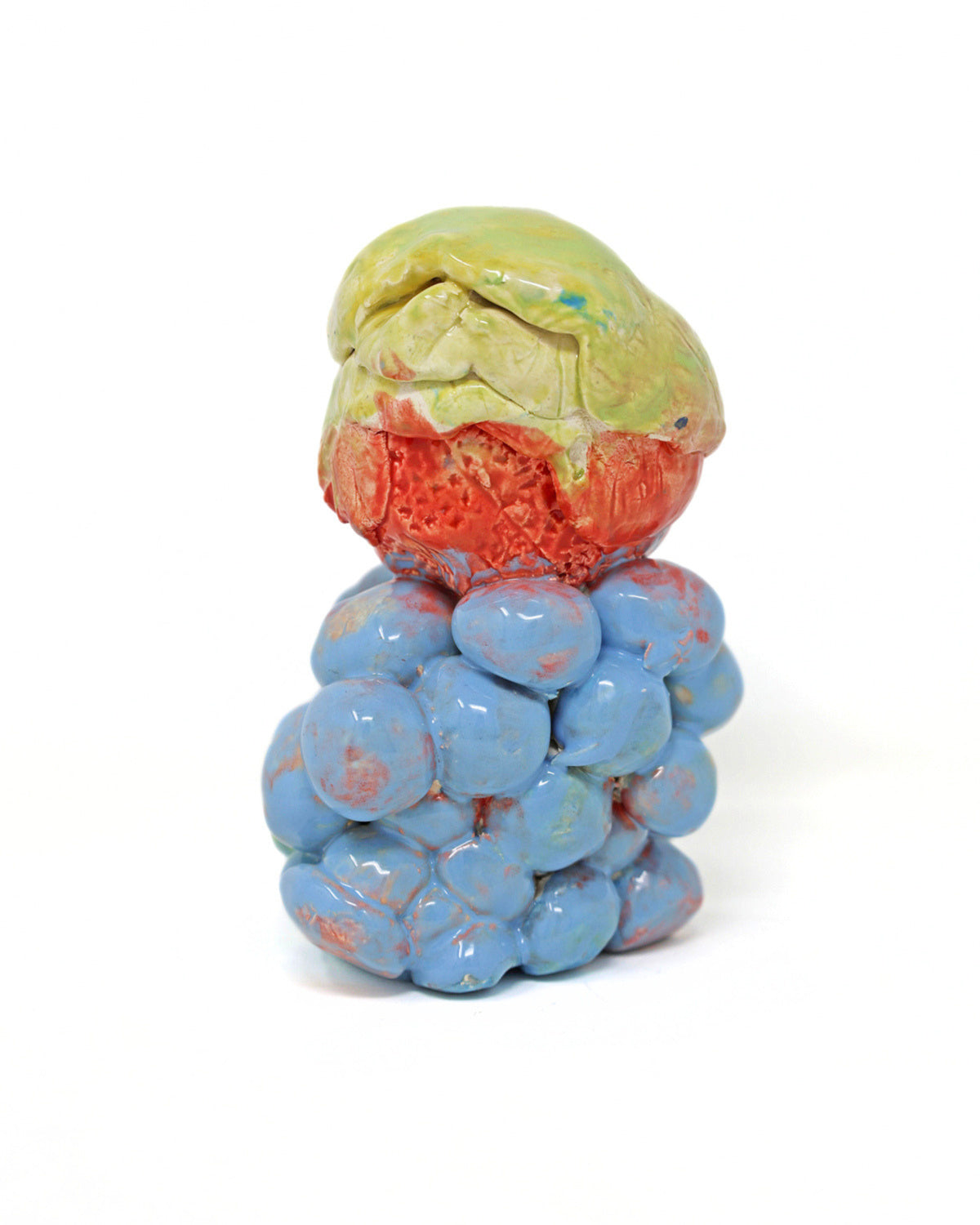 This ceramic sculpture contains one larger sphere stacked on top of many smaller spheres. The smaller spheres are connected and glazed together with a light blue glaze, with hints of red. The larger sphere on top is also attached, with the bottom half of the sphere that same red and the top half a lime green.
