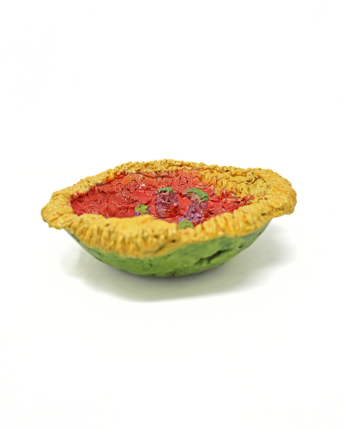 This ceramic sculpture is bowl shaped, with the outside of the bowl a bright lime green glaze and the inside a vibrant red. The lip of the bowl is glazed with a bright yellow. The piece consists of organic carvings that create a jagged texture. In the center of the bowl, there are 6 elements glazed with the same lime green that protrude from the surface.