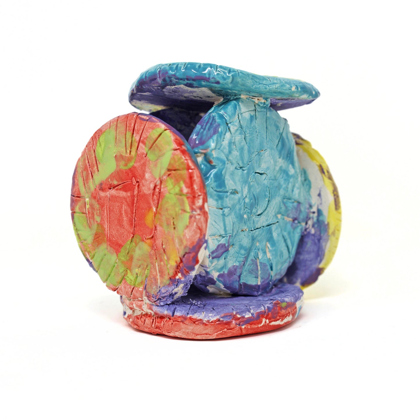 The ceramic sculpture contains 6 circles that are all connected. The piece is glazed with vibrant colors, including varying shades of green, red, blue, purple and yellow. There are also carved details on the face of each circle.
