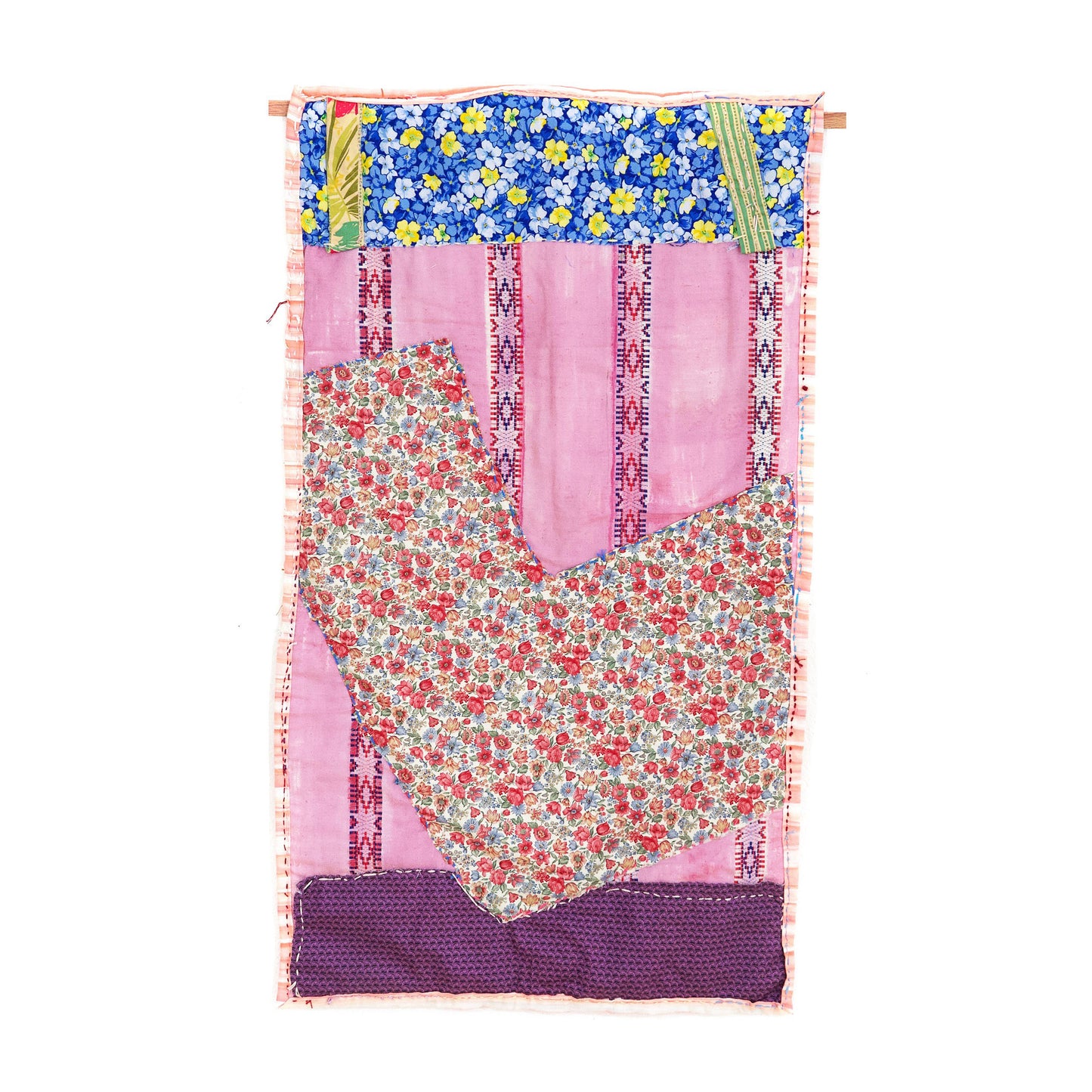 A wall-hanging fiber work. The artist combined several large pieces of patterned fabric: a blue and yellow rectangle on the top, a pink fabric with vertical strips of woven stars in the middle, a V-shaped floral fabric across the center, and a purple patterned fabric strip across the bottom. The blue and red running stitches are visible around the perimeter of each shape.