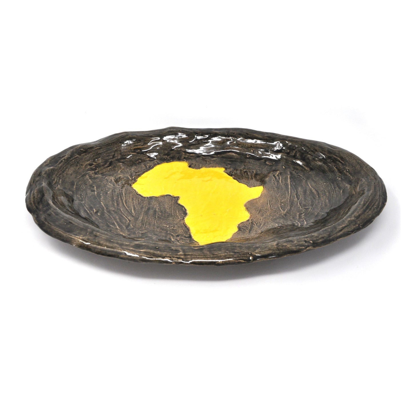 The same ceramic sculpture photographed from a lower angle. Here the rim of the bronze glazed platter is in focus. The shiny glaze reflects the light. The full description is detailed in the previous image.