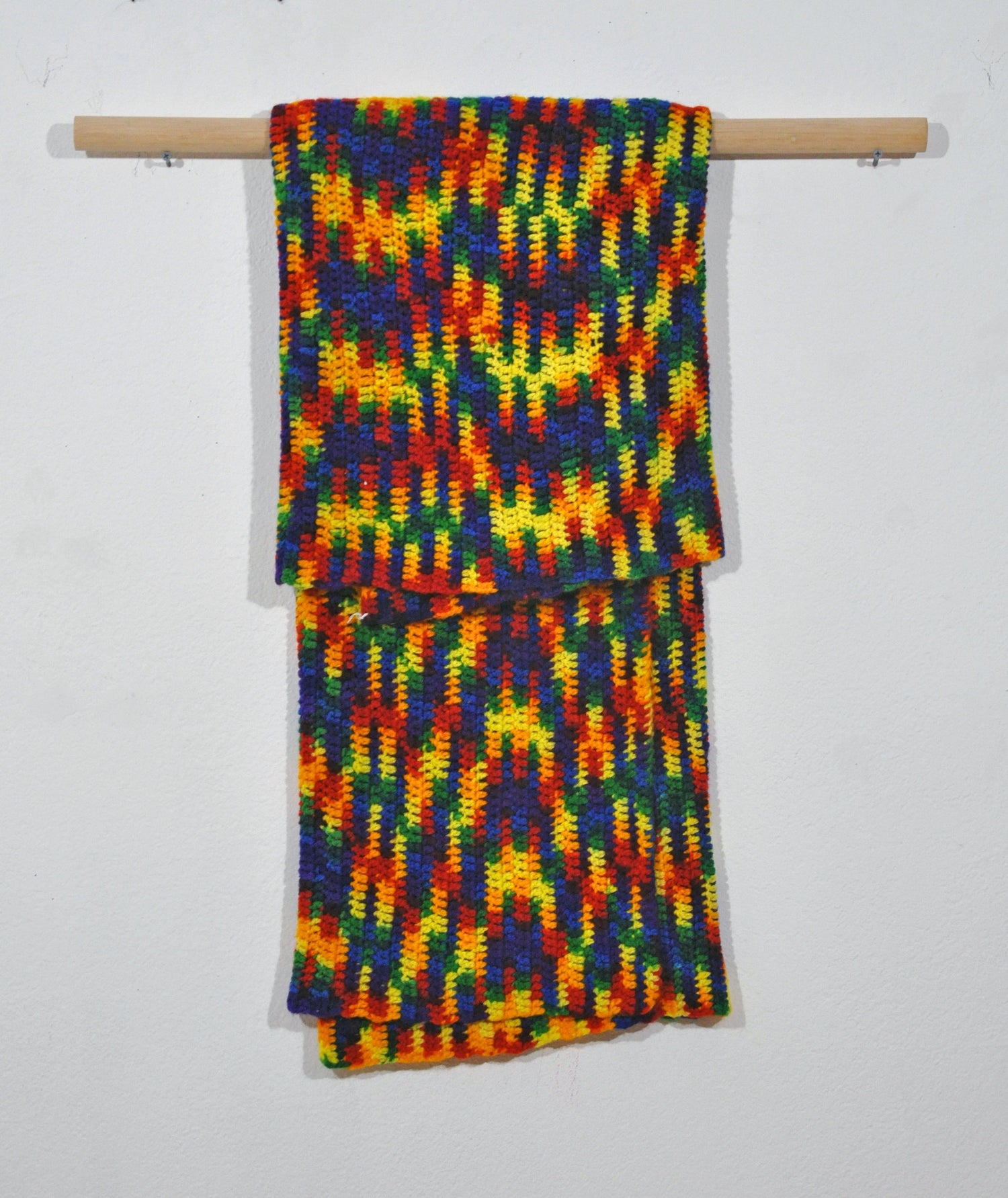 A brightly colored blanket hanging from a rod.