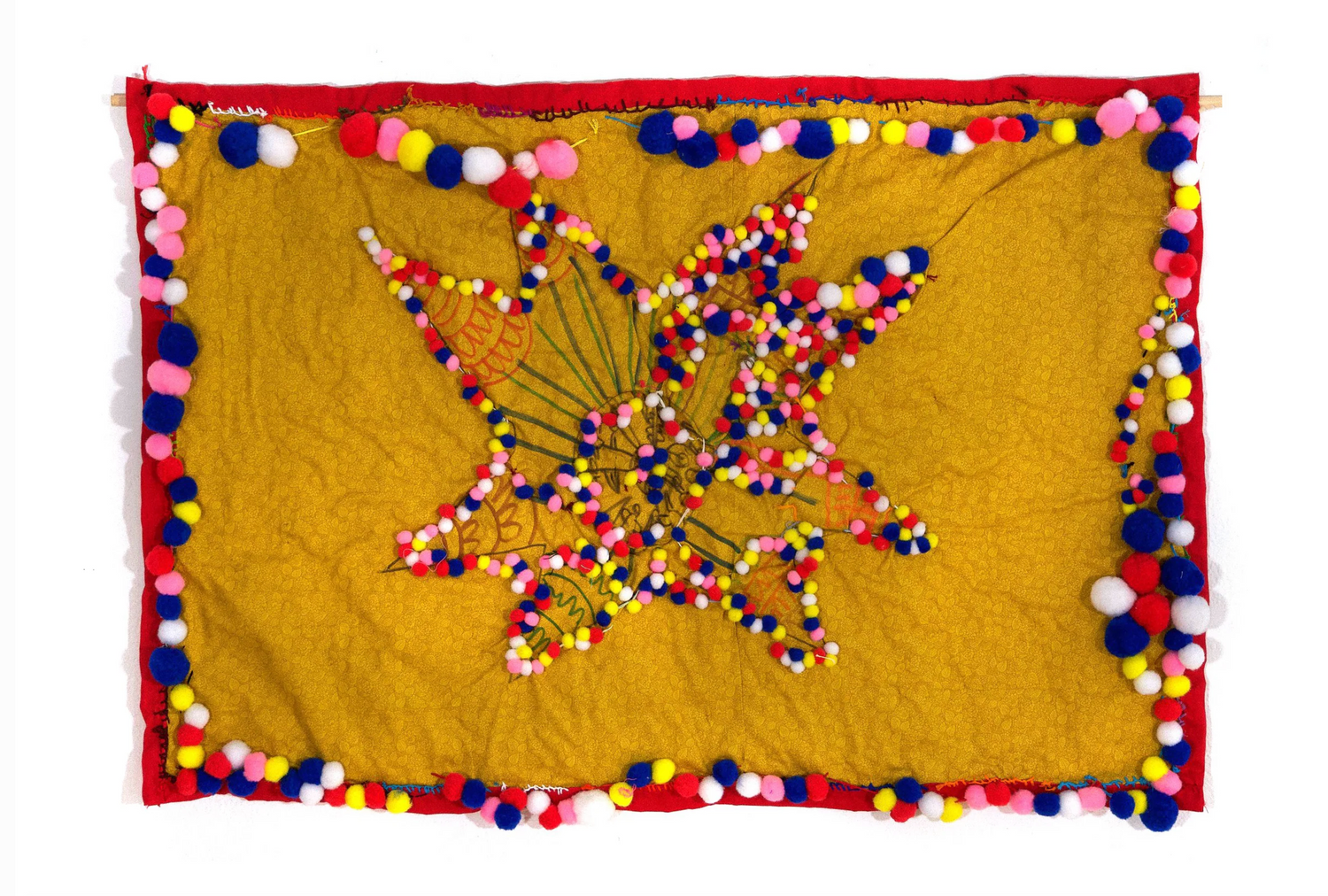 a photo of a textile artwork. A square piece of yellow fabric has a red fabric border. Tiny round pompoms in multiple colors are sewn around the border. there is a flower shape drawn in the center of the fabric with more pompom balls sewn onto its petals.