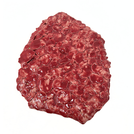 a flattened oblong ceramic object, glazed all over in shiny dark red. The object is made up of many petal forms, pressed together to cover and add texture to the entire surface. 