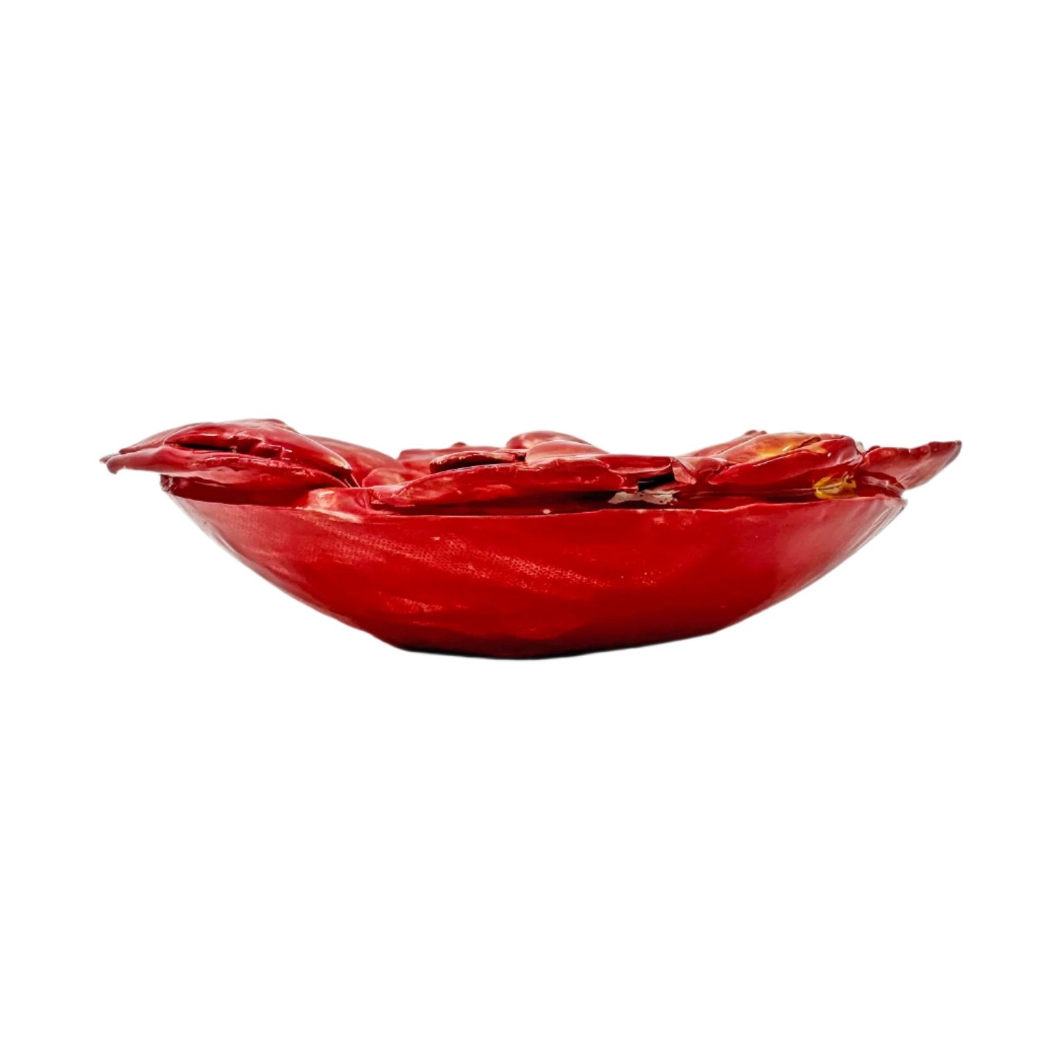 The same sculpture, photographed from the side. The exterior of the red bowl is a thin flat slab. The petal forms fill the inside and flop over the edges. 