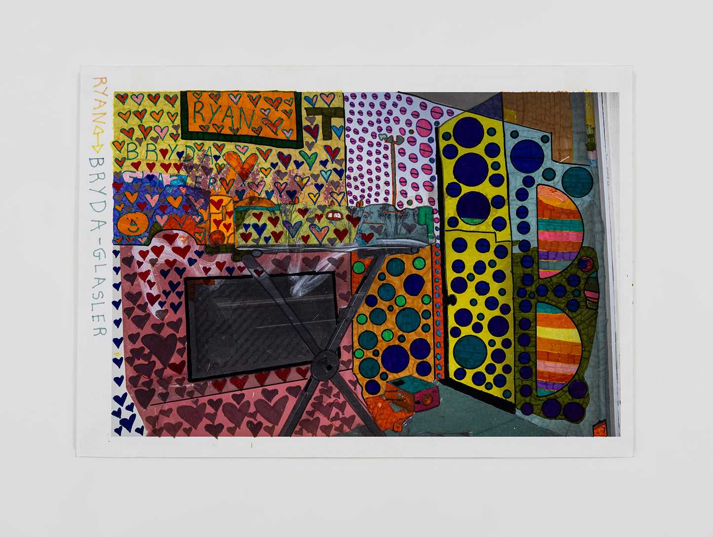 A drawing made on top of a photograph. The artist has added a field of colorful hearts, circles, stripes, and names over the image of a kitchen. 