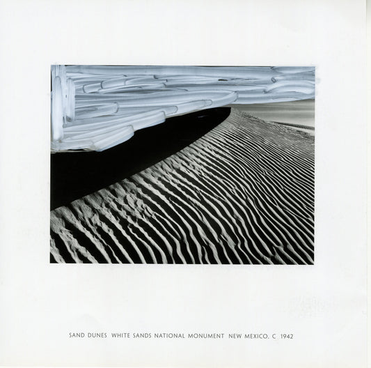 A black and white photograph by Ansel Adams capturing the rippling patterns of sand dunes at White Sands National Monument, New Mexico, dated around 1942. The foreground features intricate, parallel lines formed by the wind's effect on the sand, creating a texture of shadows and highlights. In the upper portion, there are modifications with white acrylic marker, adding broad strokes that contrast with the natural patterns of the sand. 