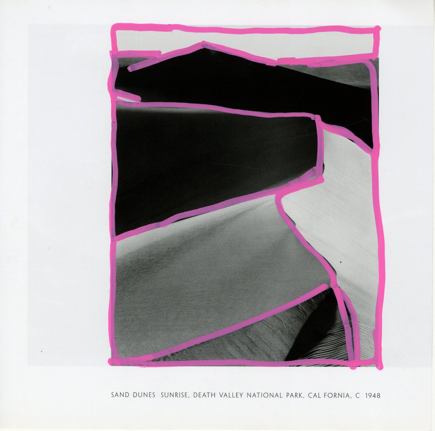 A black-and-white photograph by Ansel Adams depicting sand dunes at sunrise, located in Death Valley National Park, California. The foreground shows smooth, undulating dunes with intricate patterns of light and shadow, creating a contrast. The upper section reveals the horizon with the dark silhouette of distant dunes or mountains against the sky. On the printed photo are pink acrylic marker lines that trace irregular shapes following the contours of the dunes and edges, creating a dynamic visual overlay.
