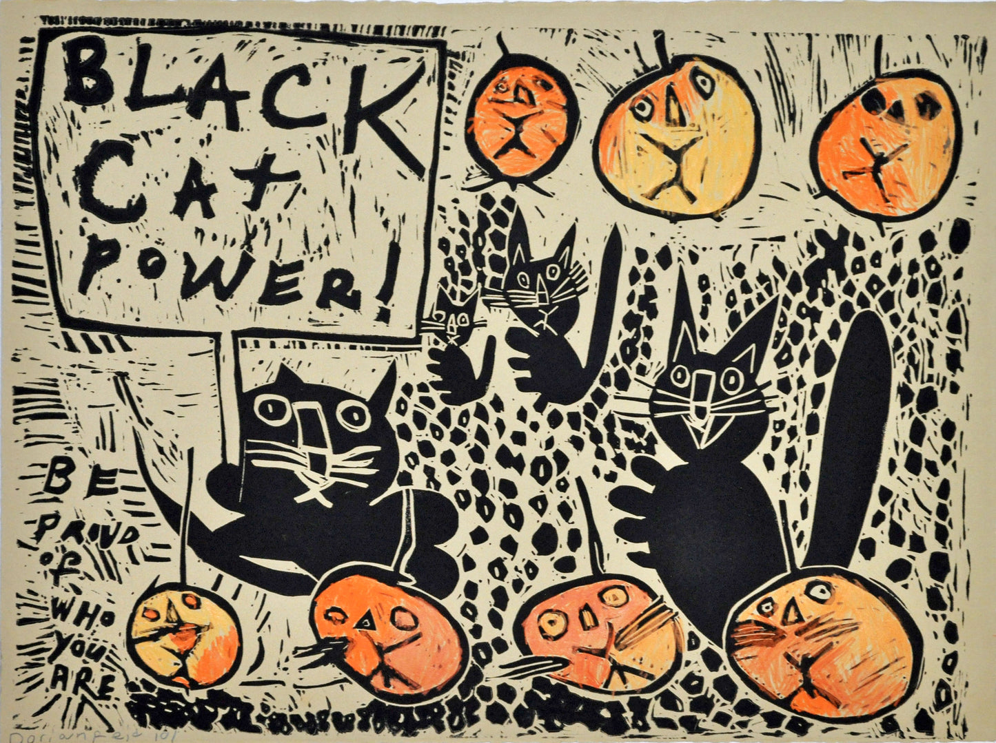 A large linoleum block print on tan paper. The image features 4 black cats and 7 orange jack-o-lantern pumpkins with cat faces. One of the black cats holds a picket sign that reads in all caps: "Black cat power!" The words "Be proud of who you are" are printed in the bottom left corner. The background is the tan of the paper with a black dot pattern carved throughout.