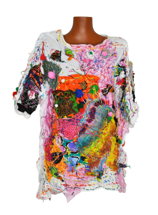 A white shirt on a mannequin with colorful embroidery and fabric patches on top.