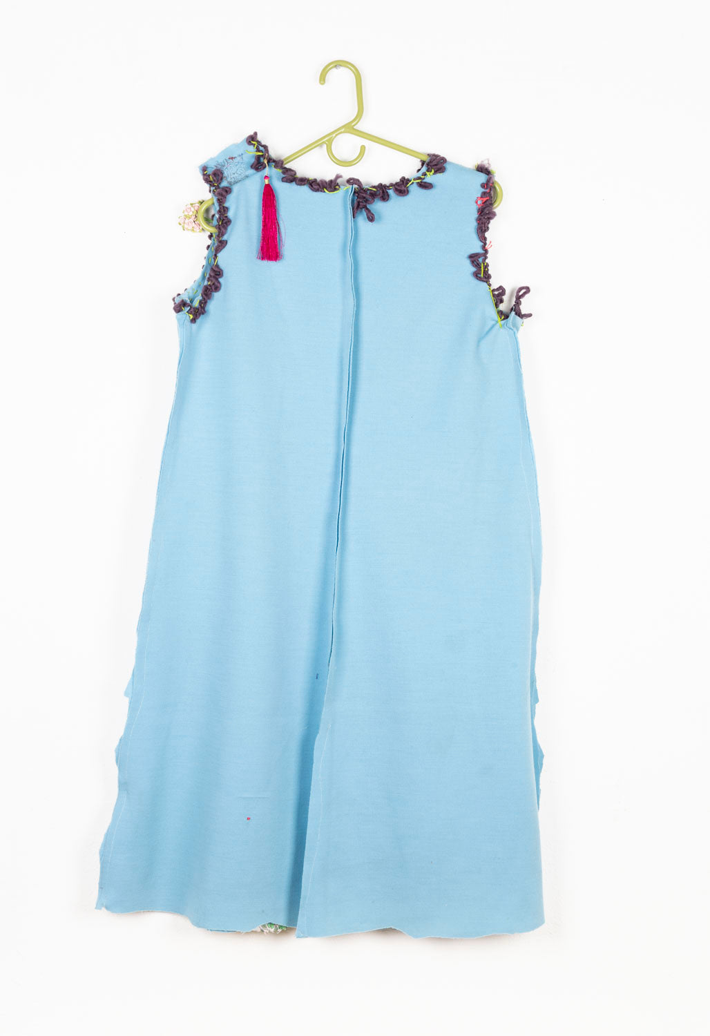 This is a light blue dress with purple embroidery on the collar and the arm holes. There is also a pink tassel on the back left shoulder.