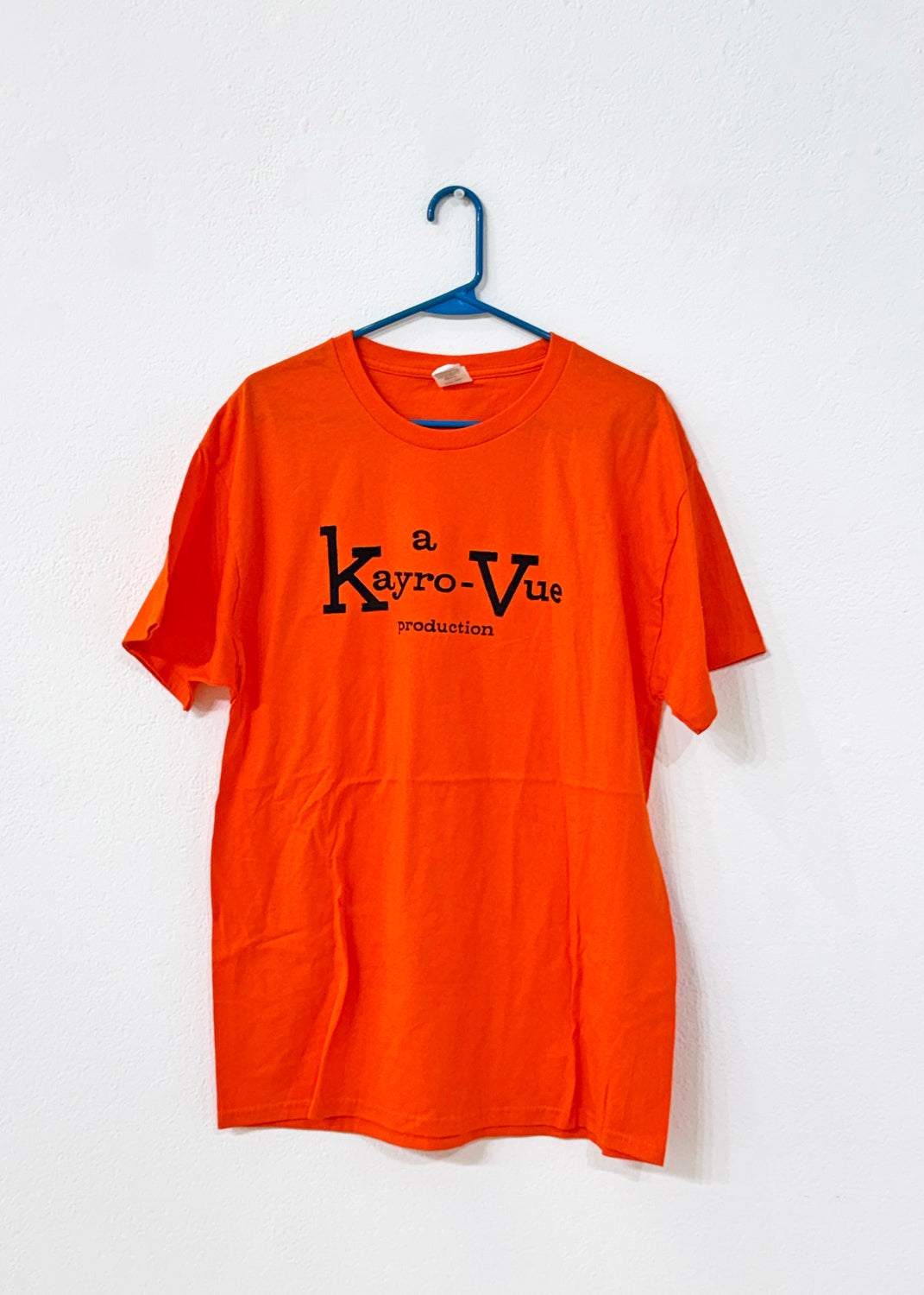 Orange t-shirt with 'Kayro-Vue' logo on a white background, hanging on a blue hanger