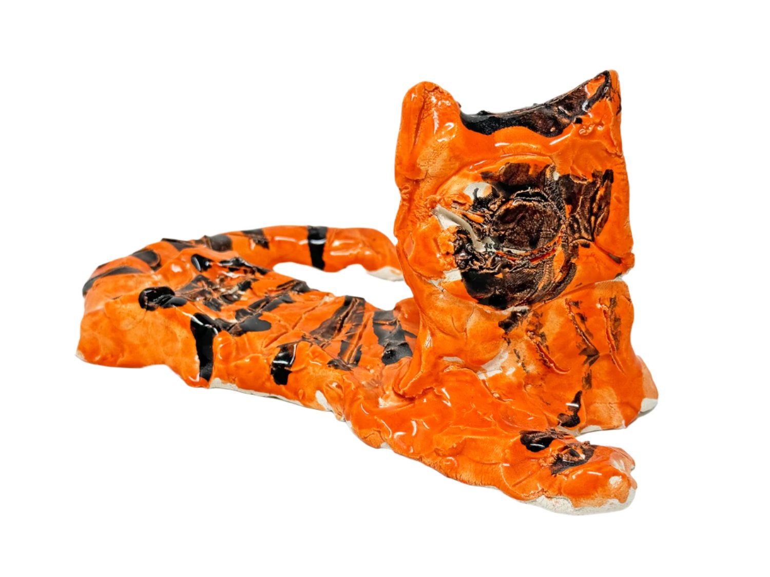 A small ceramic figurine, photographed in a white space. The form represents a seated cat or tiger, with a long flat body and face attached in an upright position, with pointed ears. The sculpture is glazed bright orange with black stripes. 