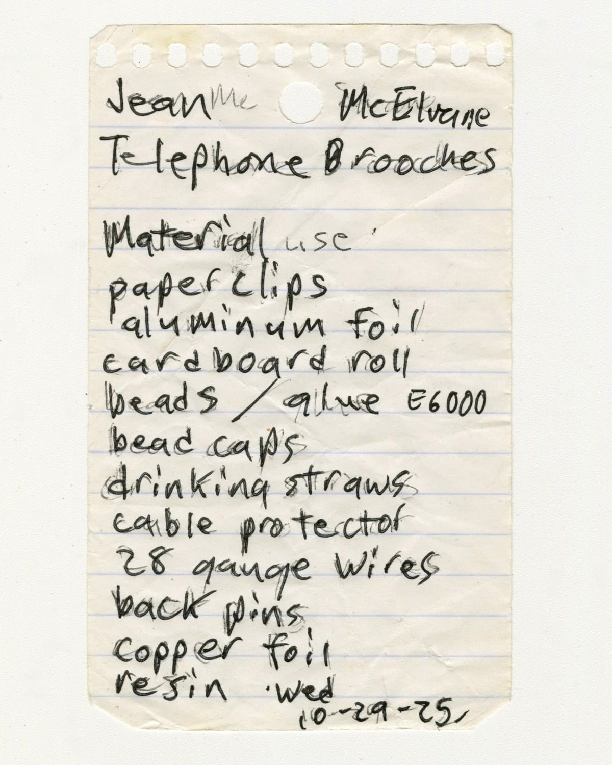 A handwritten list on a piece of paper with materials used for making telephone brooches.