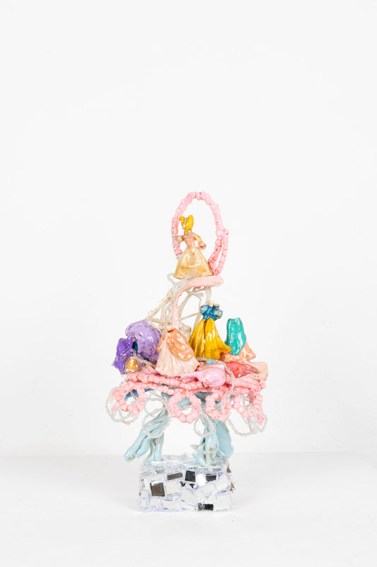 A plastic assemblage sculpture made out of melted toys with mirror mosaic base. A surreal princess ball scene on top of a powder blue running horse body. Fairy lights illuminated and strung throughout the piece.
