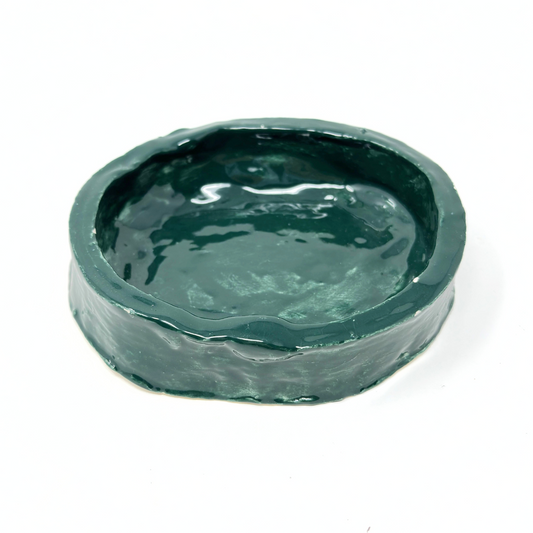 A small ceramic dish painted all over with shiny green glaze. The dish has tall straight slab walls, making it function also as a shallow bowl. 