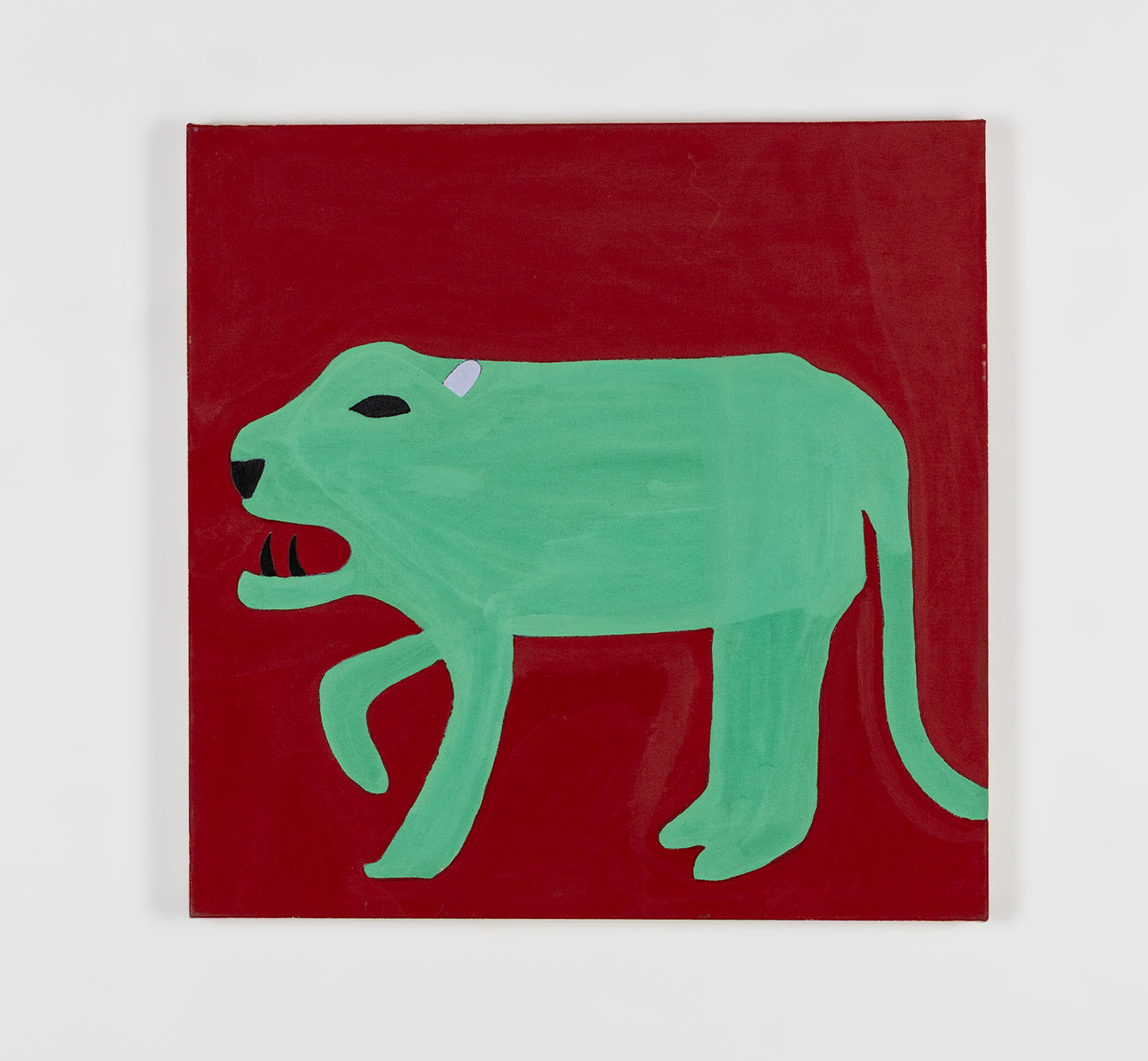 An acrylic painting on paper of a jaguar. The creature is drawn in profile, facing the left, on a dark red background. It has a black eye, two sharp black fangs, and a little pink ear. The rest of its body is painted bright green. The painting style is streamlined and flat to emphasize the silhouette of the creature.