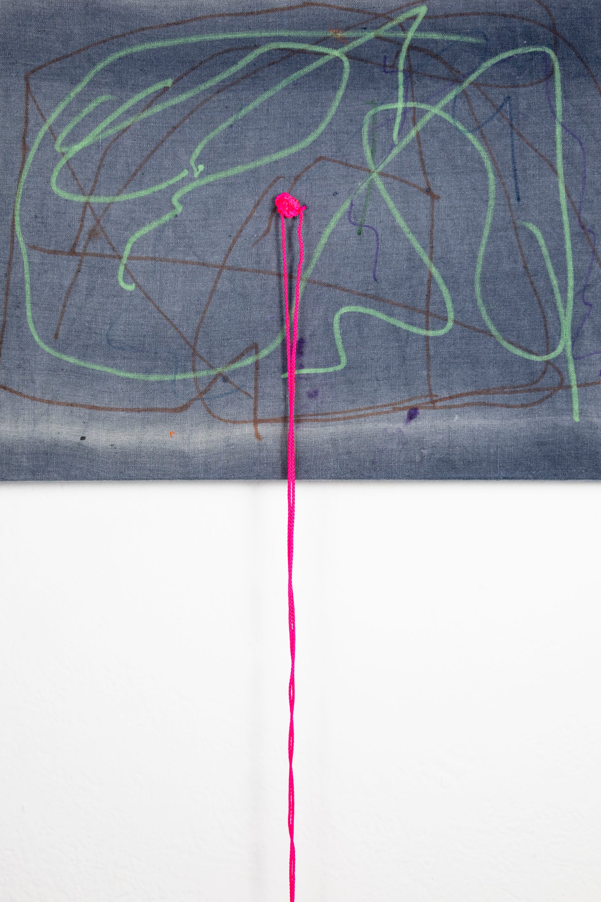  A rectangle artwork on stretched gray fabric that has been sun bleached. There are green and burgundy acrylic marker squiggle lines throughout. In the middle of the artwork, a neon pink string hadsbeen knotted and strung through, and hangs loose a few inches below the artwork.