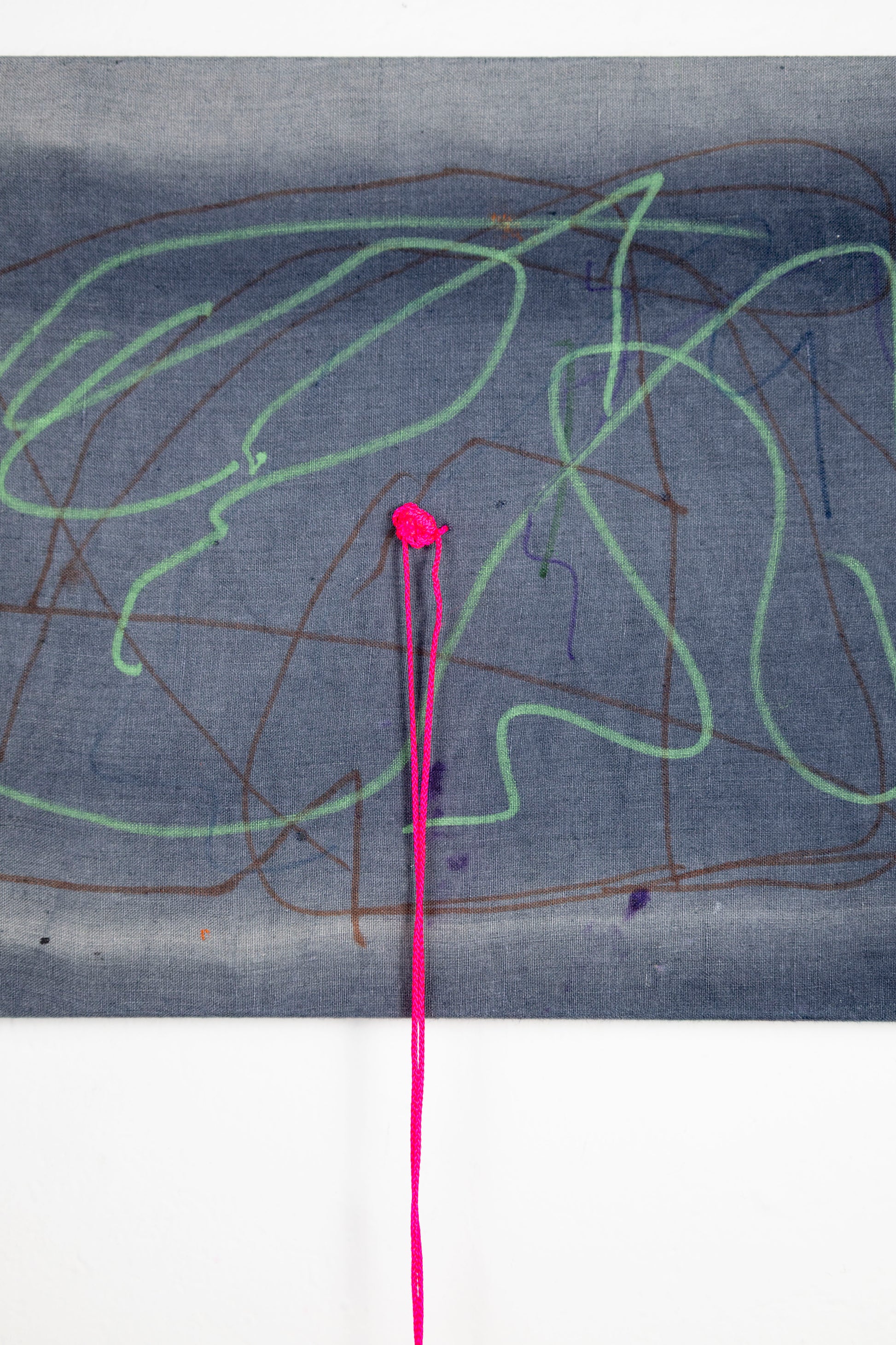  A rectangle artwork on stretched gray fabric that has been sun bleached. There are green and burgundy acrylic marker squiggle lines throughout. In the middle of the artwork, a neon pink string has been knotted and strung through, and hangs loose a few inches below the artwork.