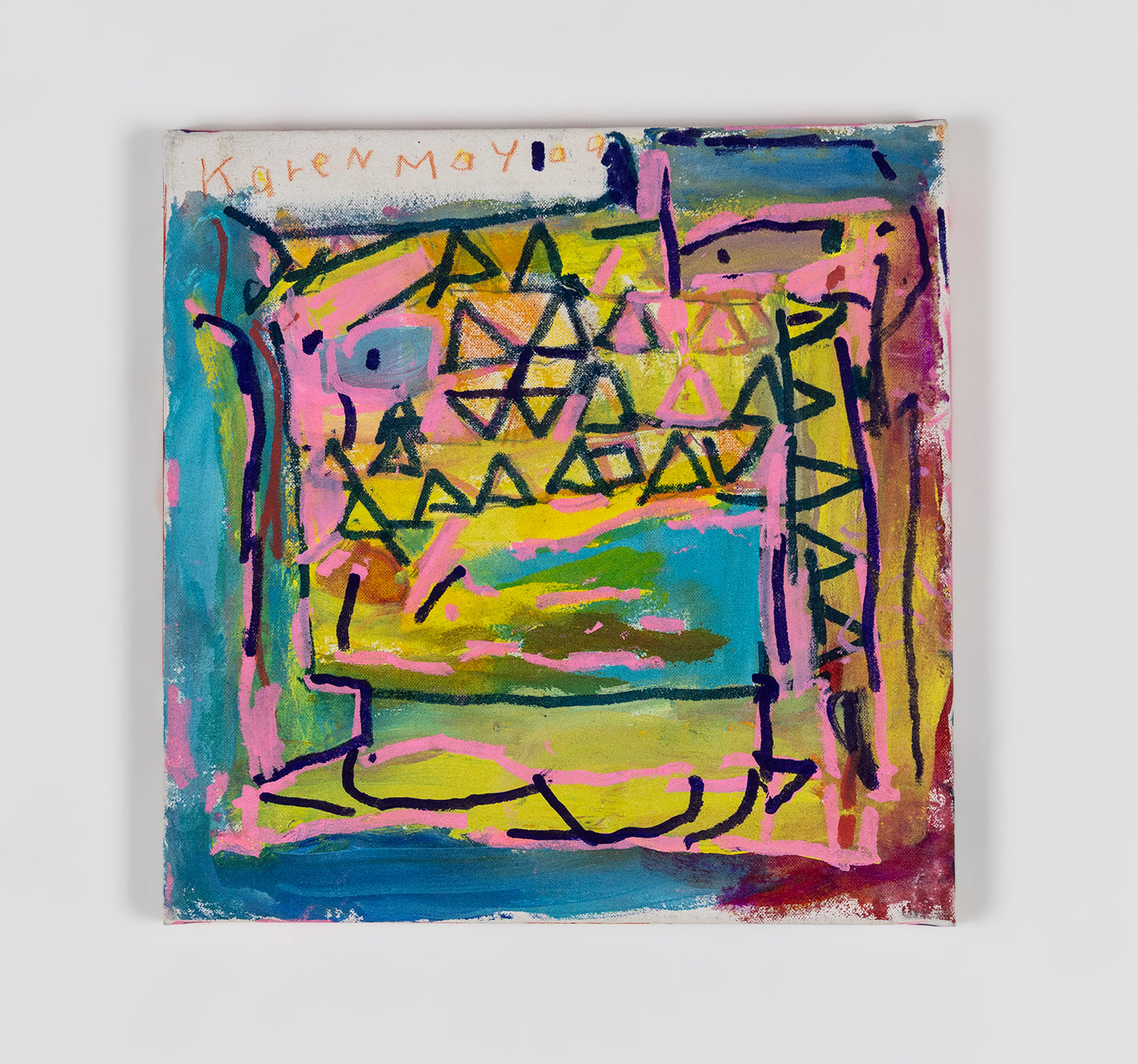 A small square abstract painting. Rows of blue and pink triangles fit together in the top half of the painting, over a background of blue and yellow wide painted marks. The artist has signed their name on the top left corner: Karen May