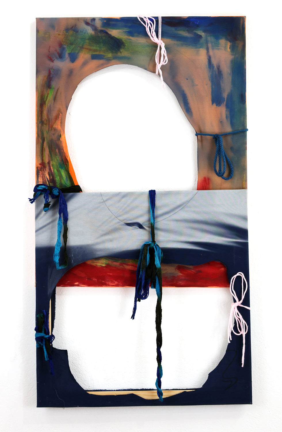 Abstract artwork of two stretched fabric panels against a white background that have been attached to form a vertical rectangle. Each portion has one large hole, and the wooden stretcher bars are exposed in some areas. The top panel has a slightly pink color, with blue, green, and red brushwork. The bottom panel is blue with white sun bleach. Both panels have yarn ties that extend from the holes to the stretcher bars. 