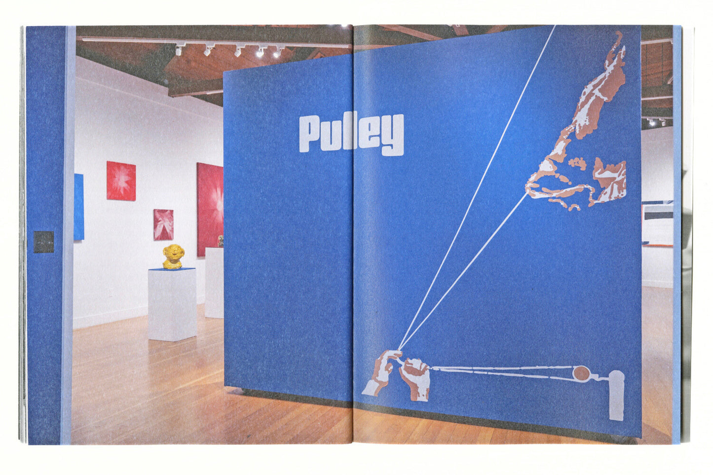 Open book showing a photo of the Pulley exhibition at Berkeley Art Center. 