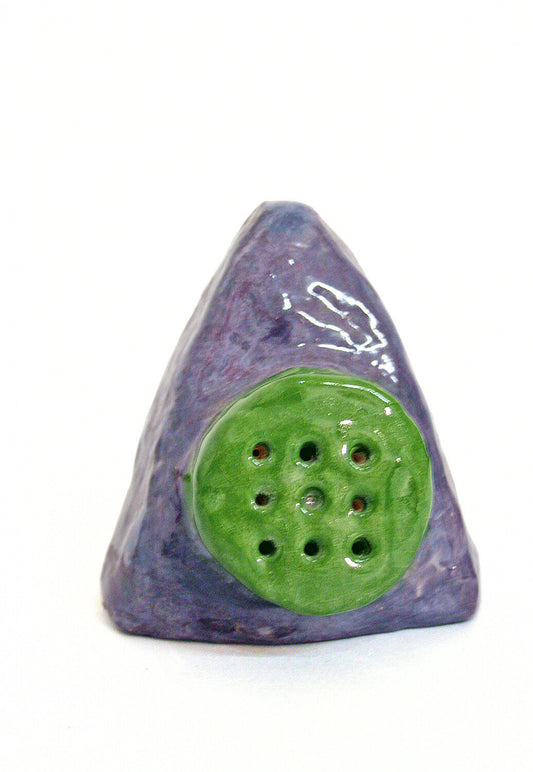 A triangular purple ceramic with a green circle in the middle. The circle is perforated nine times. 