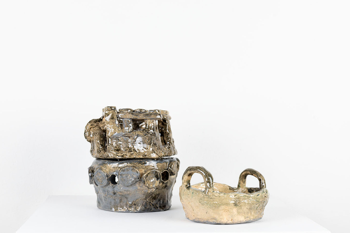 The same sculpture photographed to show that the layers can be unstacked and displayed separately. Here, the pan is sitting on the pedestal next to the other two forms which are still stacked. 