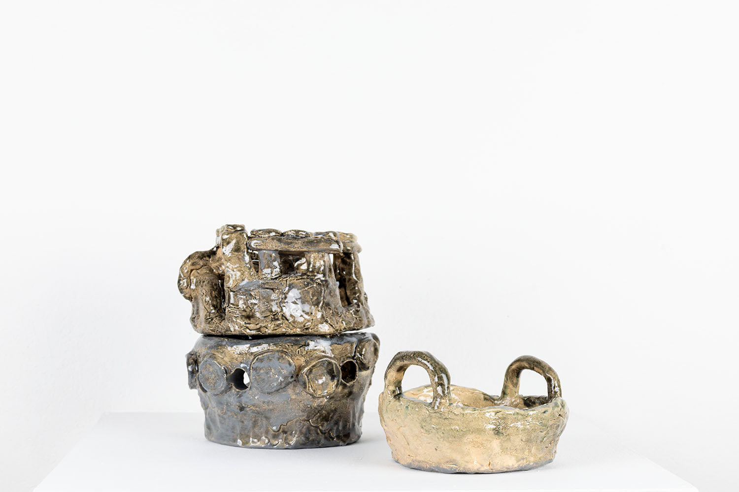 The same sculpture photographed to show that the layers can be unstacked and displayed separately. Here, the pan is sitting on the pedestal next to the other two forms which are still stacked. 