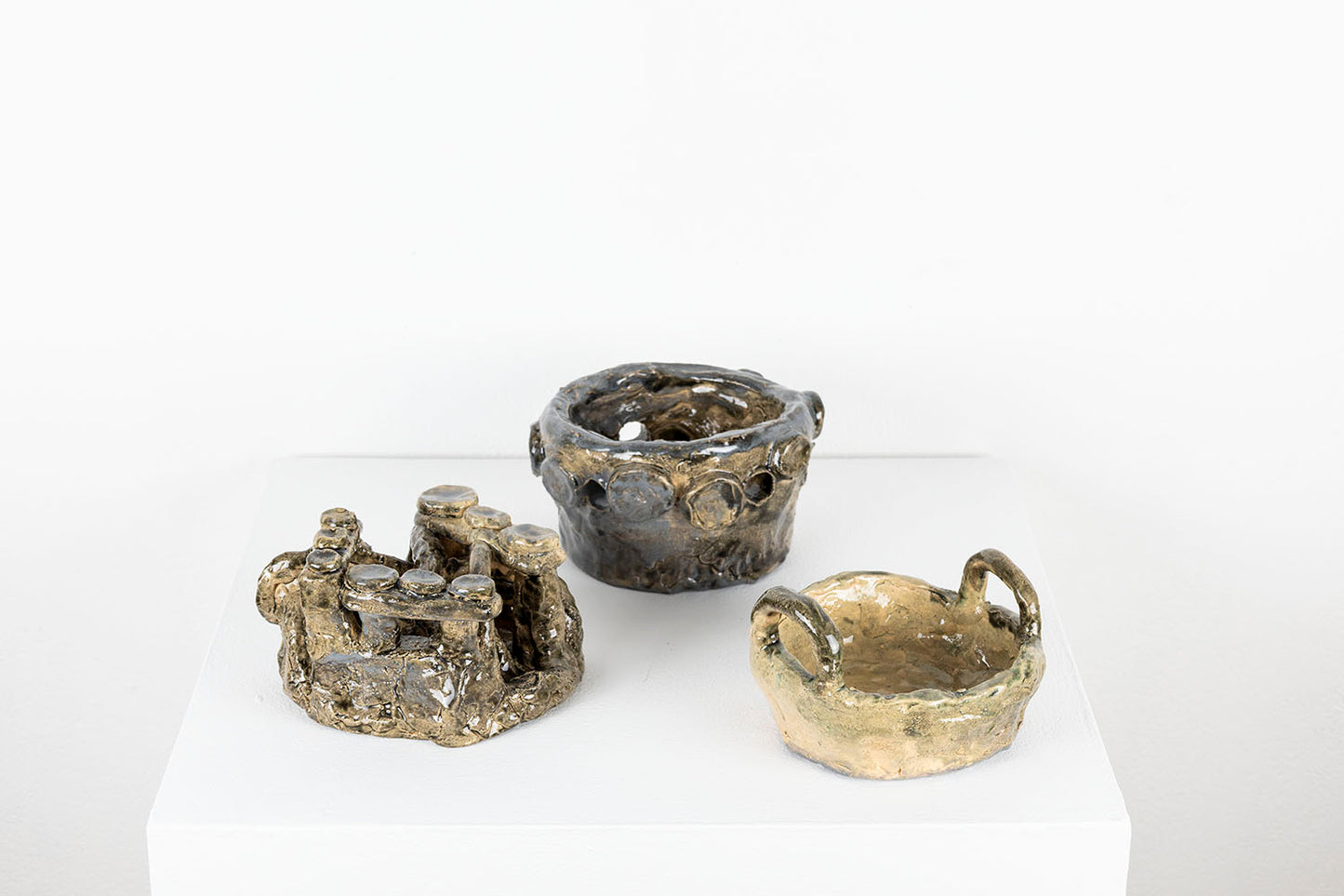 The same sculpture photographed to show that the layers can be unstacked and displayed separately. Here each of the three objects are arranged side by side on the pedestal. 