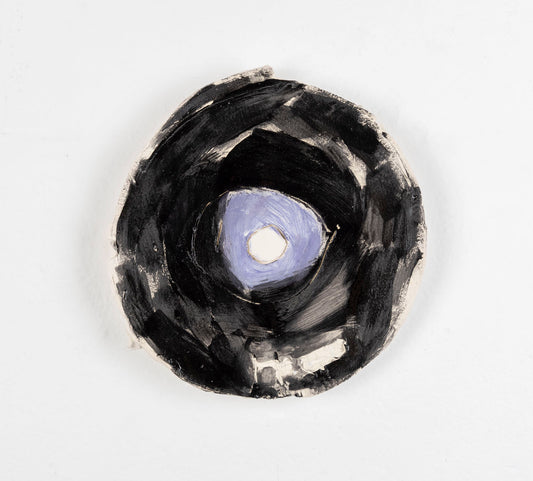 This is a ceramic sculpture of a record, the majority of the record is glazed in black, with a purple glaze for the center.
