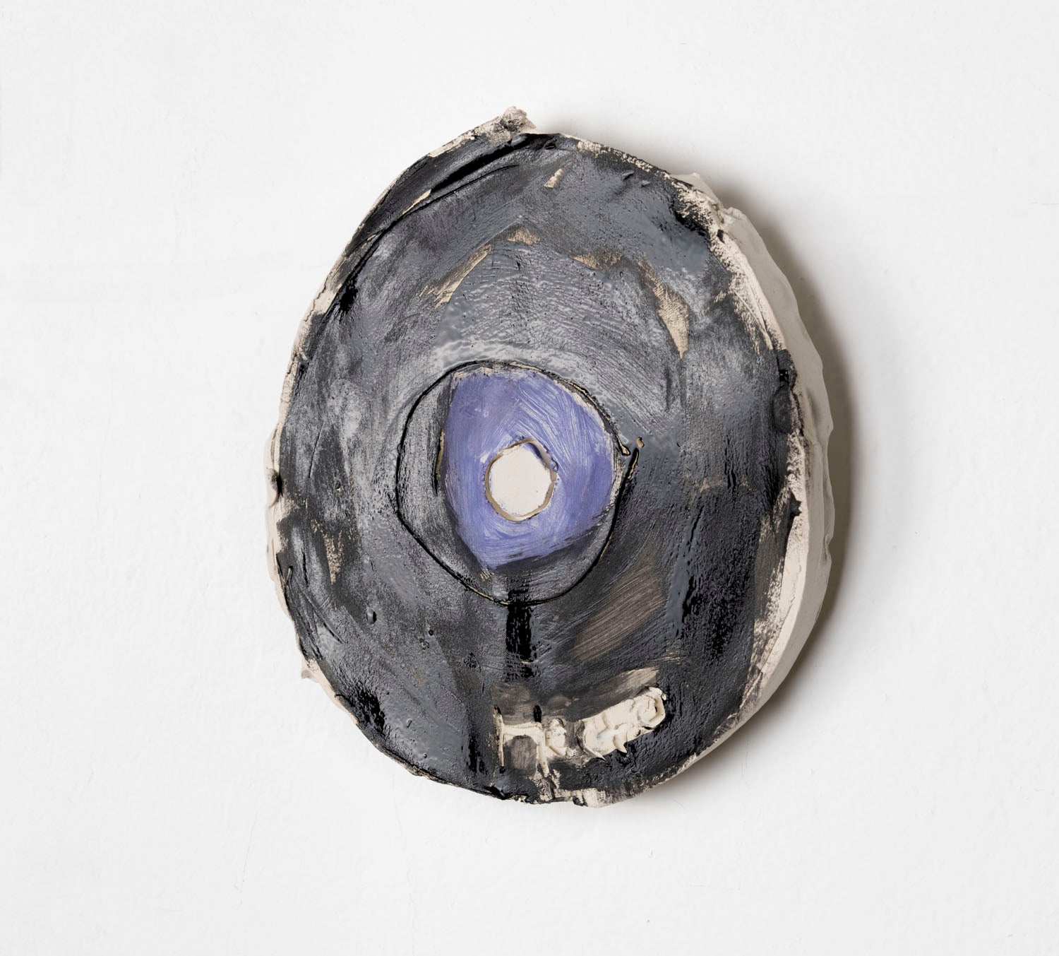 This is a ceramic sculpture of a record, the majority of the record is glazed in black, with a purple glaze for the center.