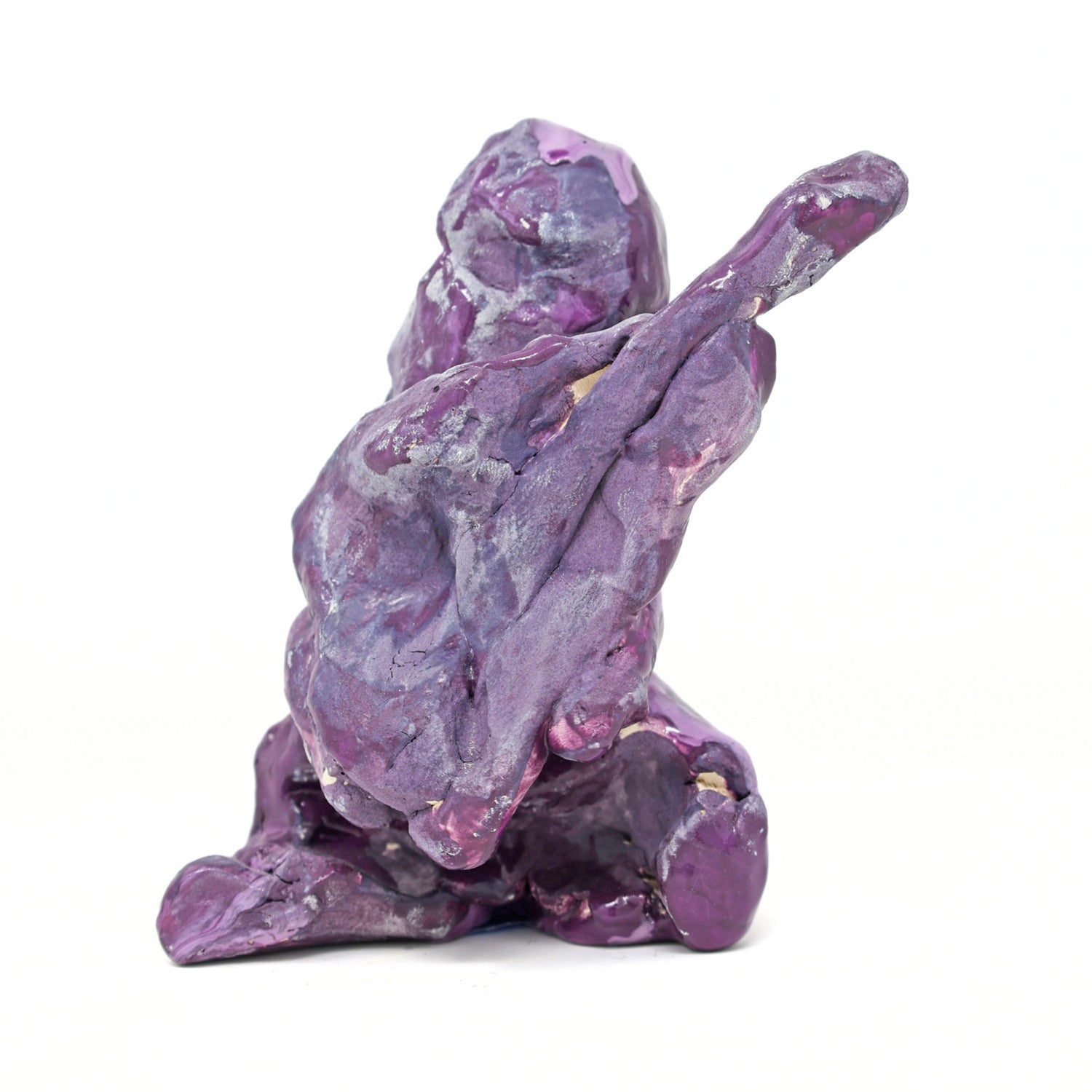 This is an abstracted ceramic sculpture of prince. There is a vague figurative form that is holding a guitar. The entire sculpture is glazed in shades of purple and blue. 