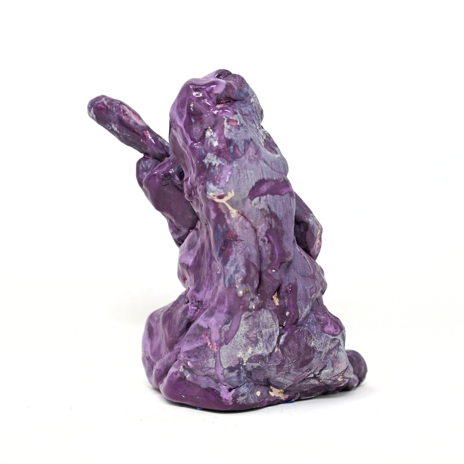 This is an abstracted ceramic sculpture of prince. There is a vague figurative form that is holding a guitar. The entire sculpture is glazed in shades of purple and blue. 