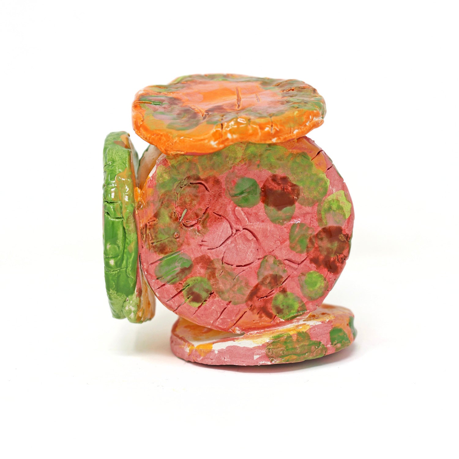 The ceramic sculpture contains 6 circles that are all connected. The piece is glazed with vibrant colors, including varying shades of green, orange and pink. There are also carved details on the face of each circle.
