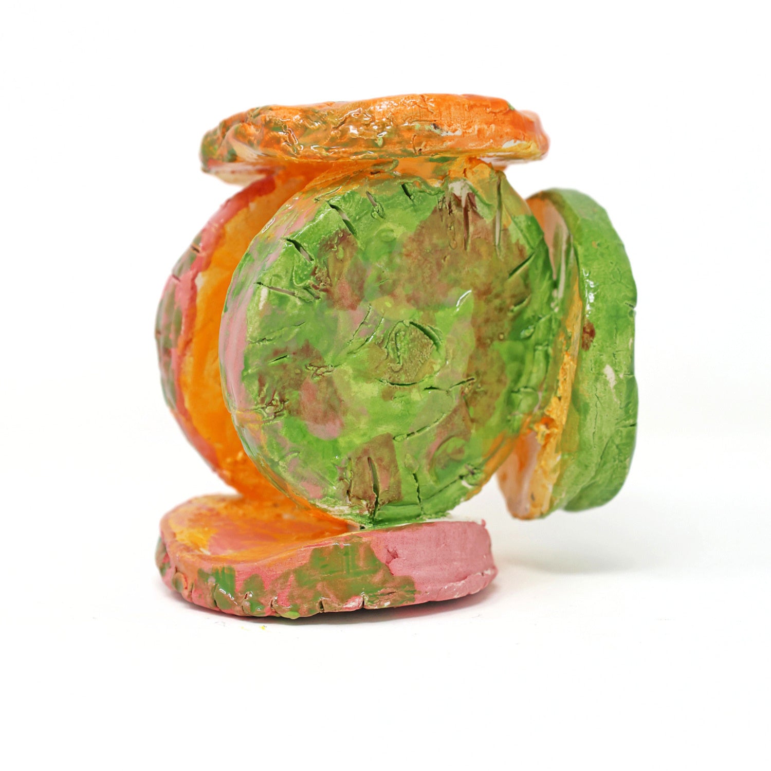 The ceramic sculpture contains 6 circles that are all connected. The piece is glazed with vibrant colors, including varying shades of green, orange and pink. There are also carved details on the face of each circle.
