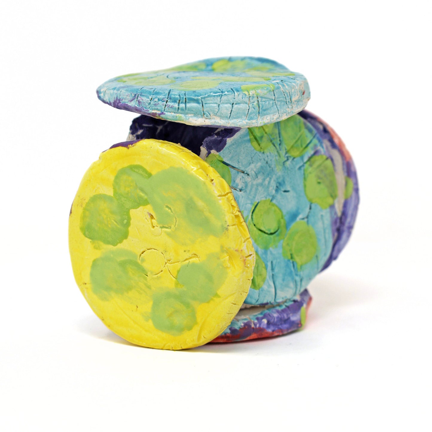 The ceramic sculpture contains 6 circles that are all connected. The piece is glazed with vibrant colors, including varying shades of green, red, blue, purple and yellow. There are also carved details on the face of each circle.