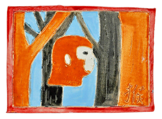 a small rectangular tile with a red border. The central image is a side view of an orange monkey head with orange and black tree trunks on both sides. A light blue background shows through the tree branches. 