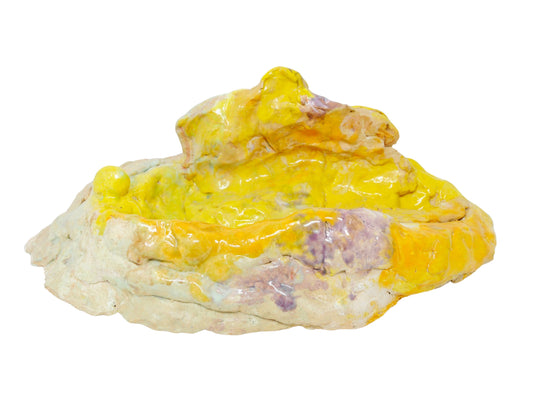 an abstract ceramic sculpture. The form has a wider base and narrows toward the top. It's glazed all over in glossy yellow, with spots of purple and white. 