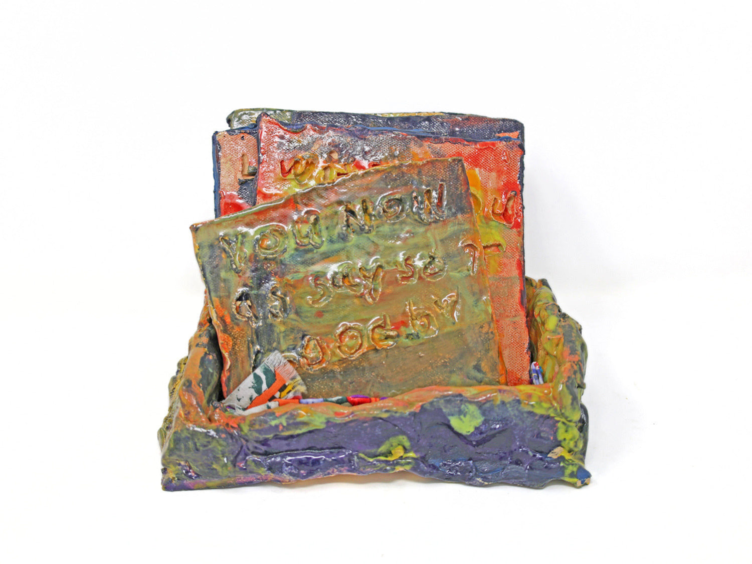 This ceramic sculpture has a base with five removable tablets. Text is carved onto both sides of the removable tablets, and are glazed with pink purple and yellow glaze. 
