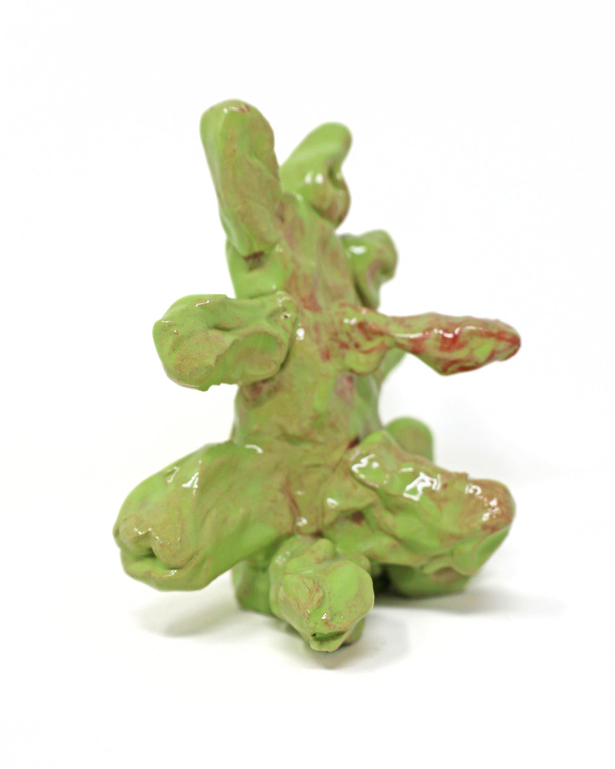 This abstract sculpture is heavily coated in a lime green glaze. The thick application of glaze creating a drooping effect. The piece has 7 appendages that protrude from the center.