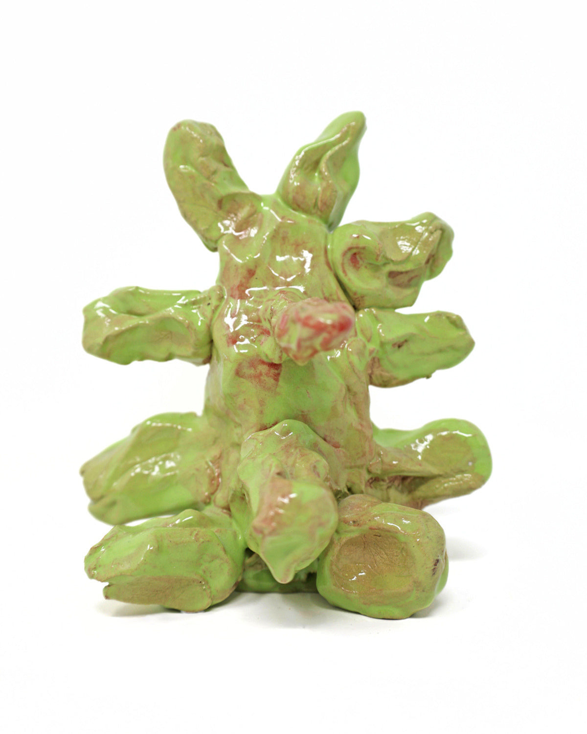 This abstract sculpture is heavily coated in a lime green glaze. The thick application of glaze creating a drooping effect. The piece has 7 appendages that protrude from the center.