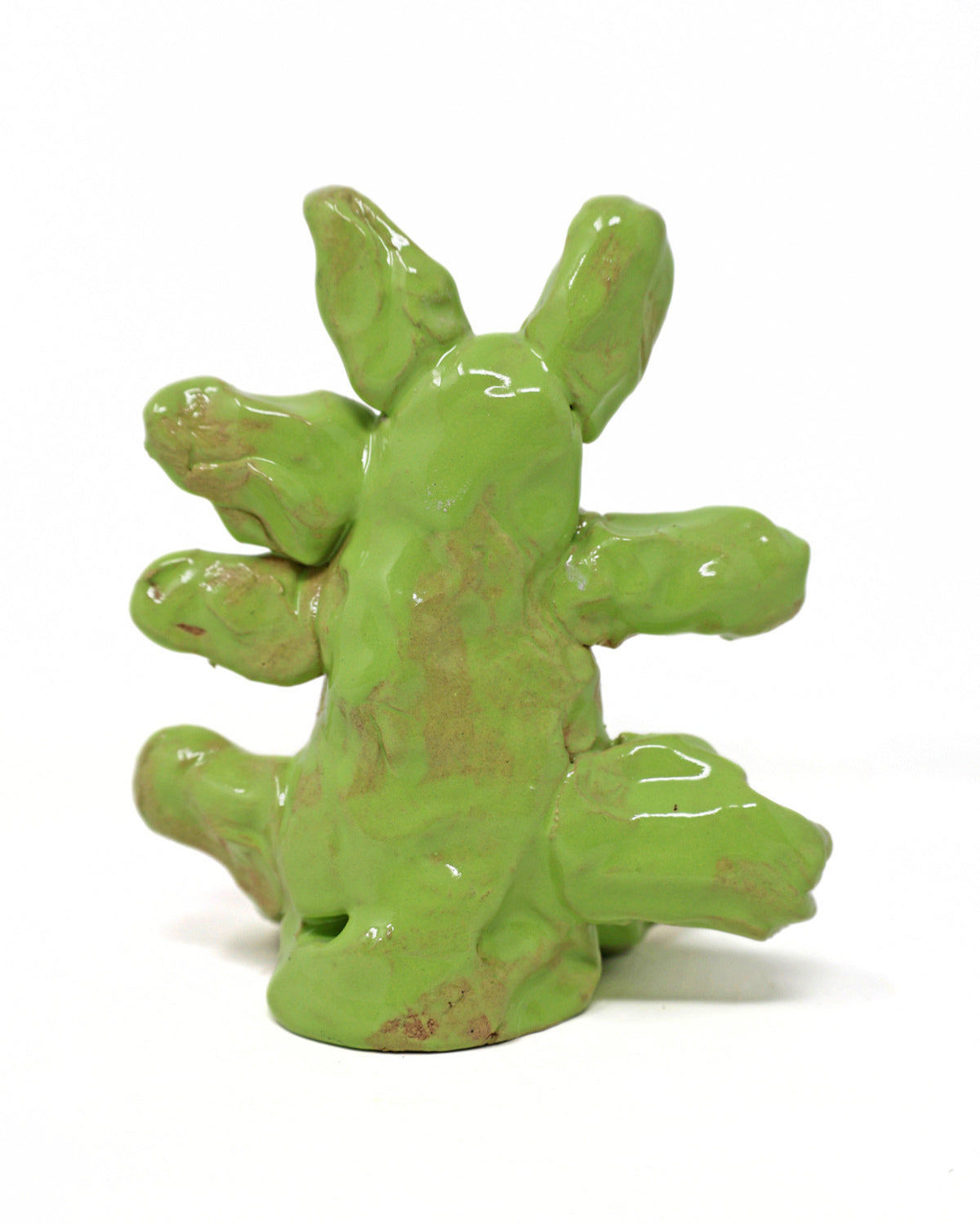 This abstract sculpture is heavily coated in a lime green glaze. The thick application of glaze creating a drooping effect. The piece has 7 appendages that protrude from the center.