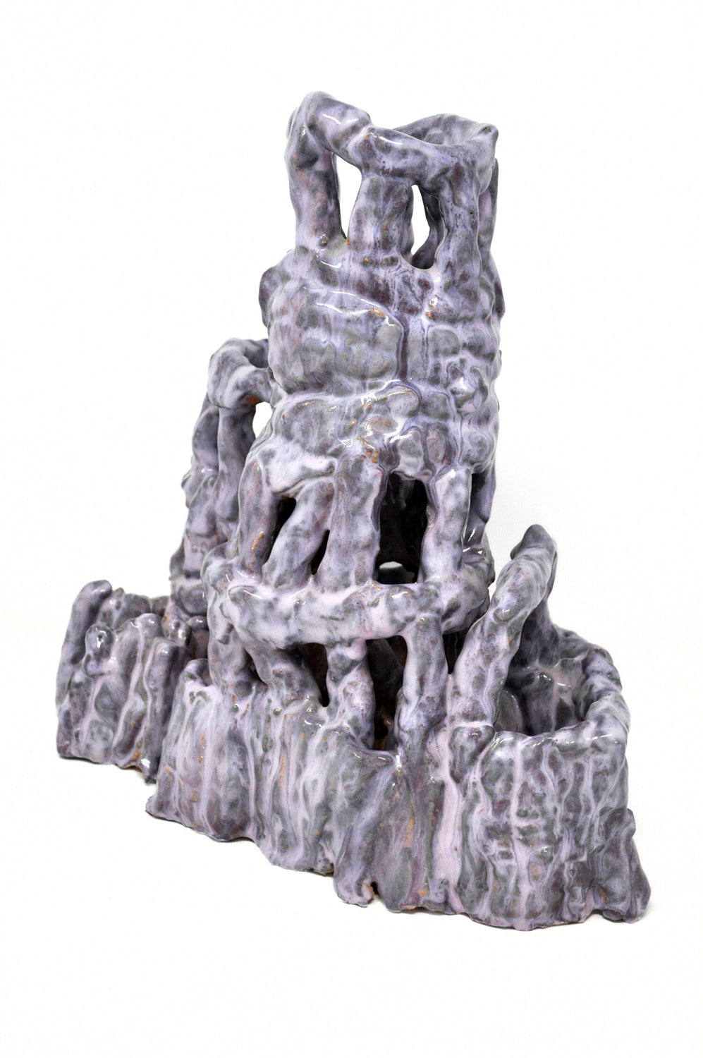 A ceramic sculpture of a tower. Glossy lilac glaze is layered over a darker purple glaze to create a mottled texture. The tower is three tiers and wider at the base. It's made of little cylinders: some are stacked vertically and others are wrapped around the tower in horizontal bands. There are gaps between each cylinder through which the white background is visible.