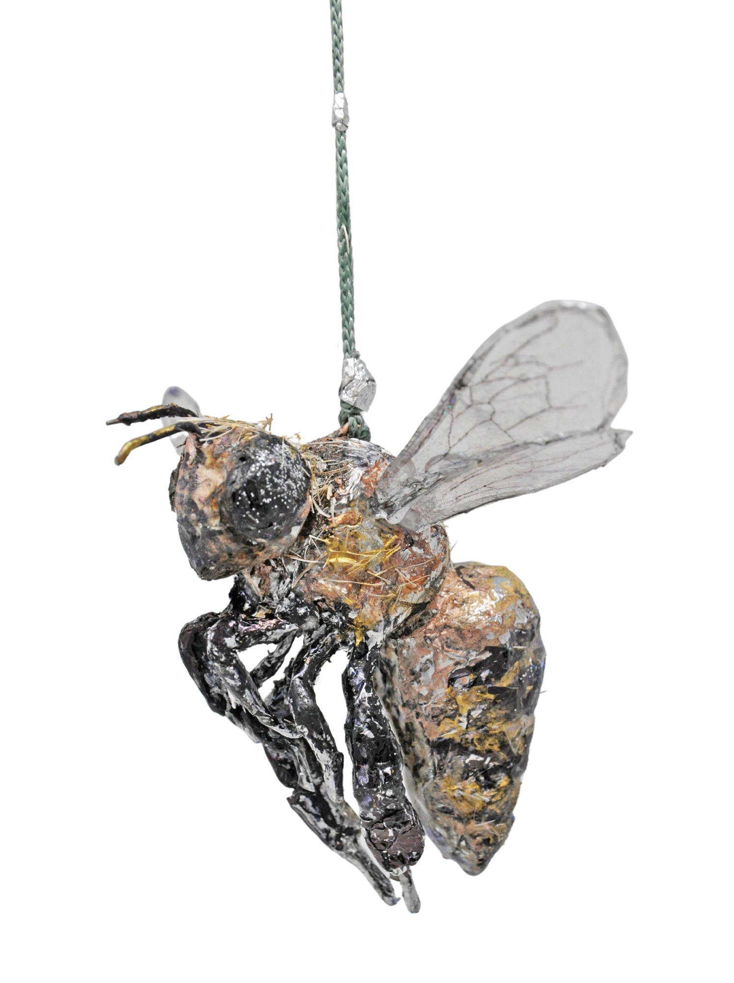 The same object photographed from a slightly different angle. Here, the front of the bee and its 6 curled legs are more clearly in focus. The wings are angled out from the body as if the bee is hovering in flight. A full description of the object is detailed in the previous image. 