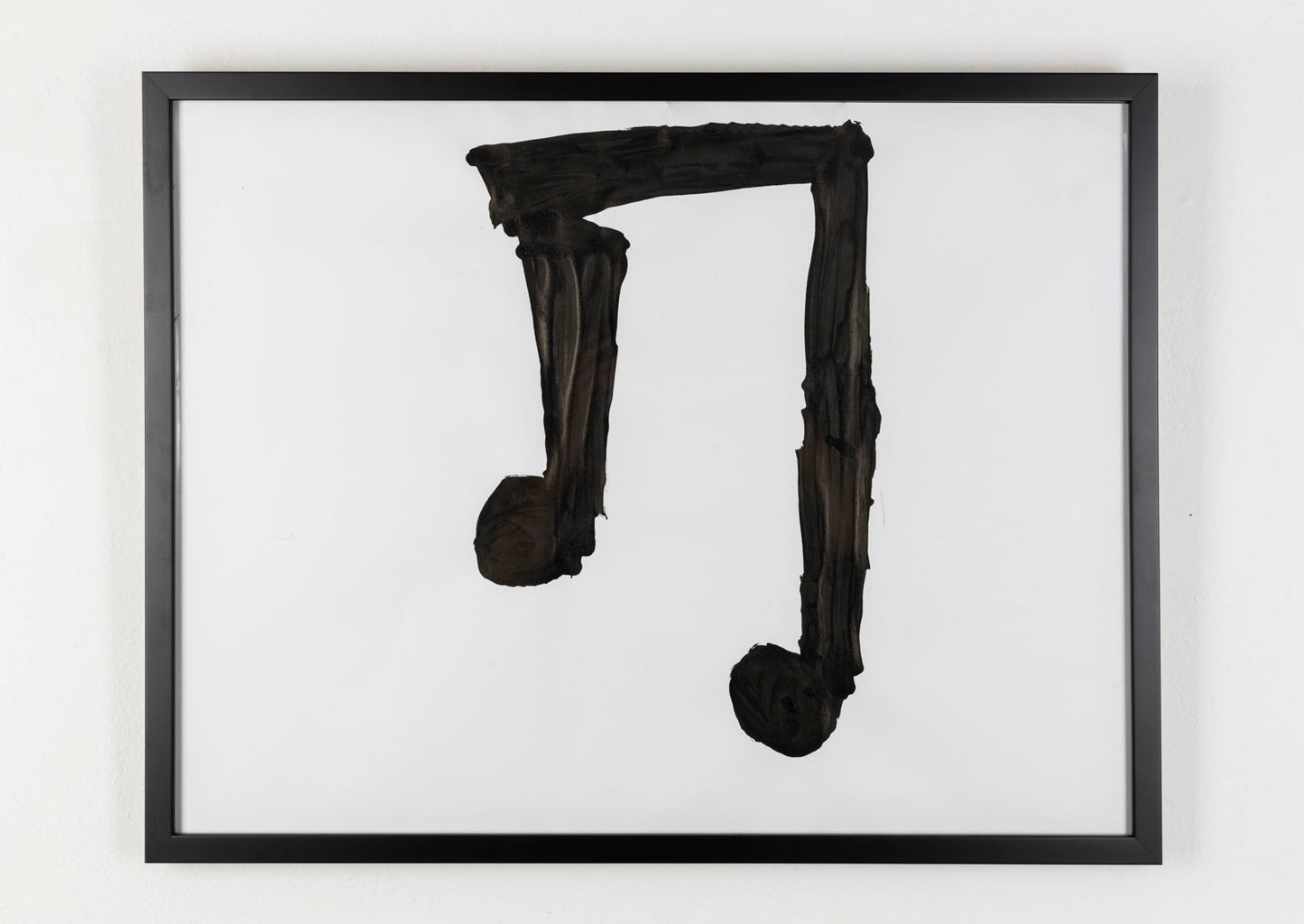 This piece is a large musical note that is painted in black against a white background.