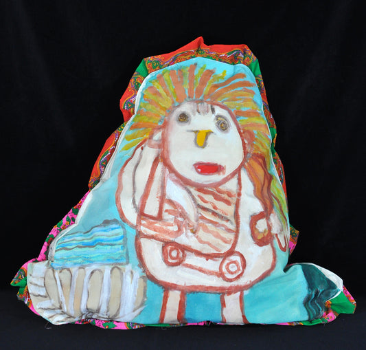 a triangular shaped sculpture with a multicolored fabric border. The front of the pillow shows a white outlined figure over a light blue background. 